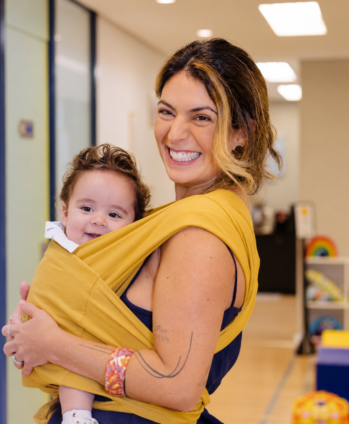Dra. Lígia sorrindo com um bebê no colo